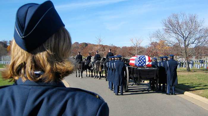 Sharon walking behind her father's casket at Arlington.